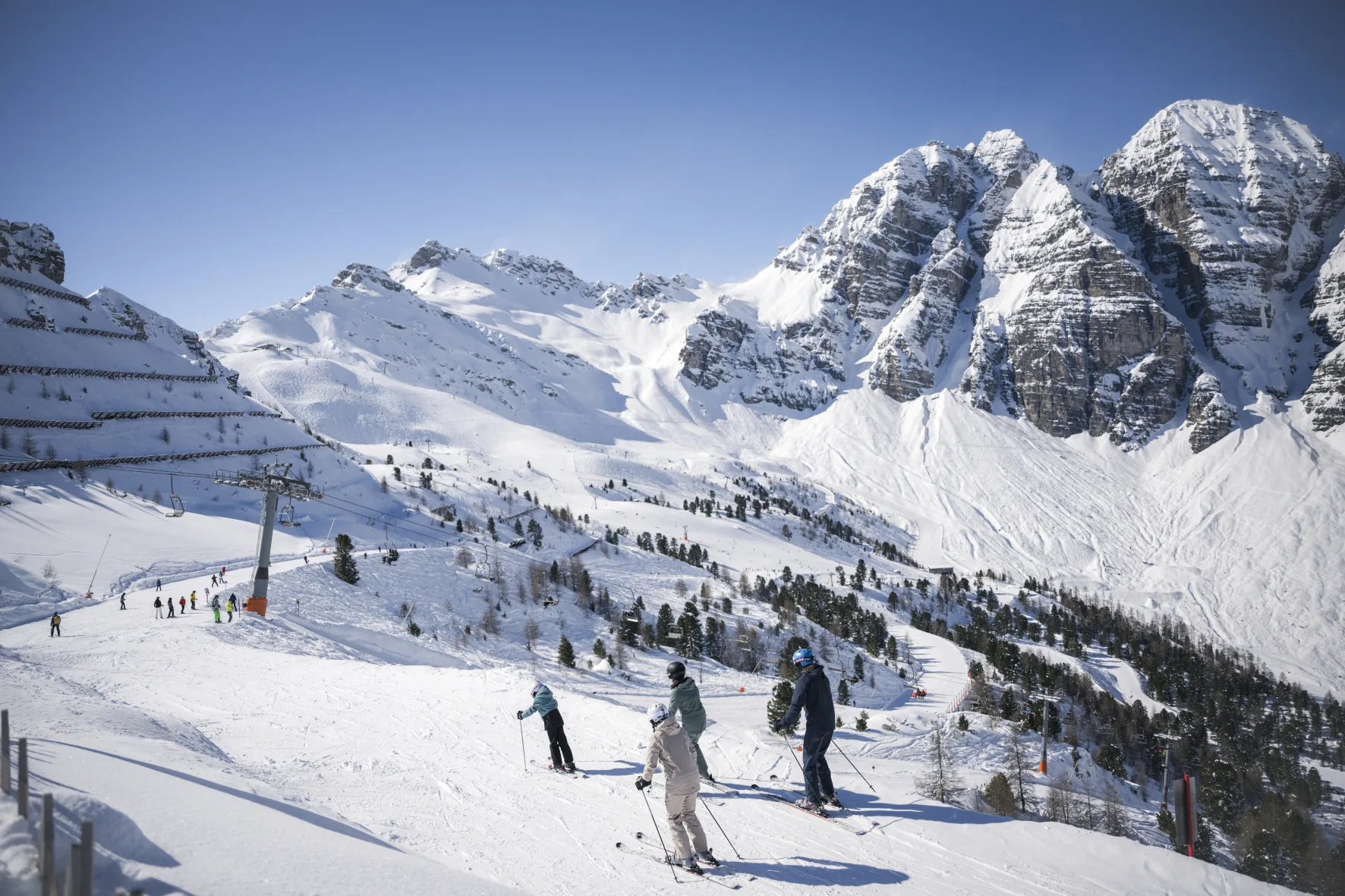 Skifahrer auf der Piste im Stubaital vor verschneiten Gipfeln